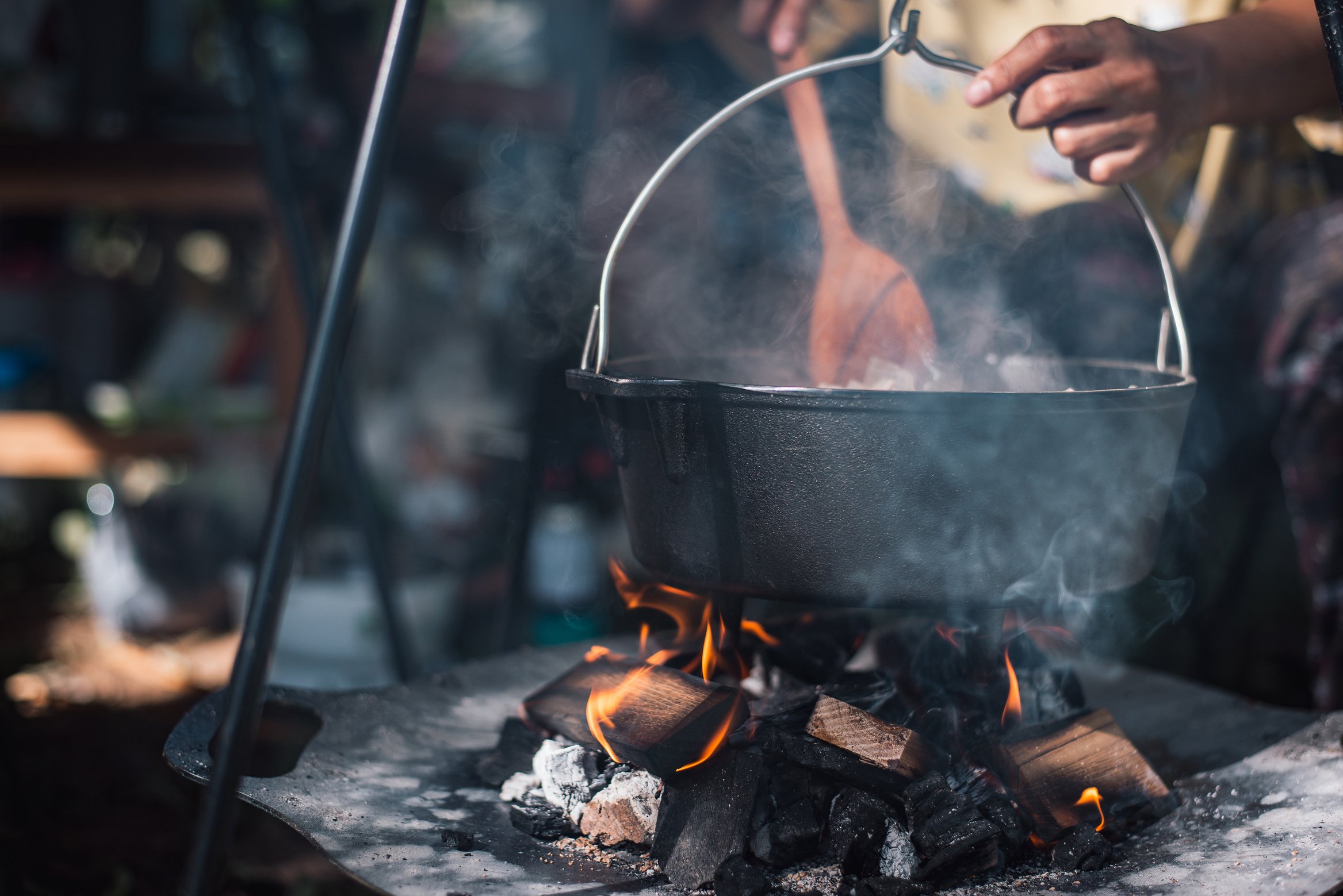 Preparing food on campfire in wild camping,Cooked food on a campfire on a camping trip. Camp kitchen, cooking food in the forest on fire. Frying pan on fire. Camping life concept.